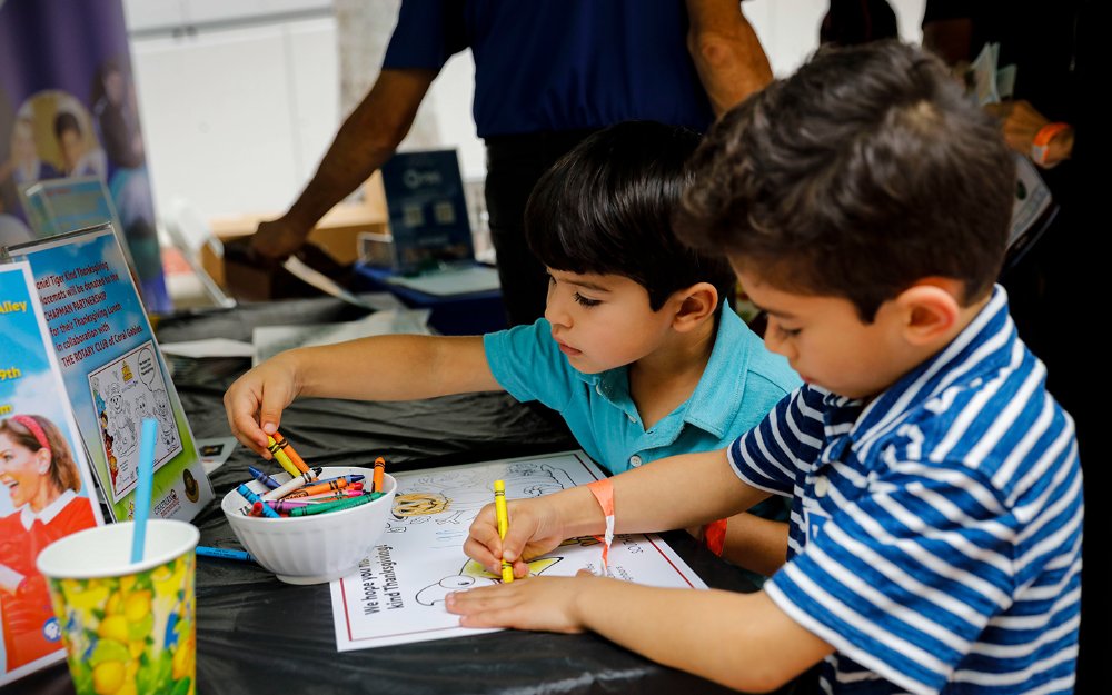 Boys coloring together at Children's Alley