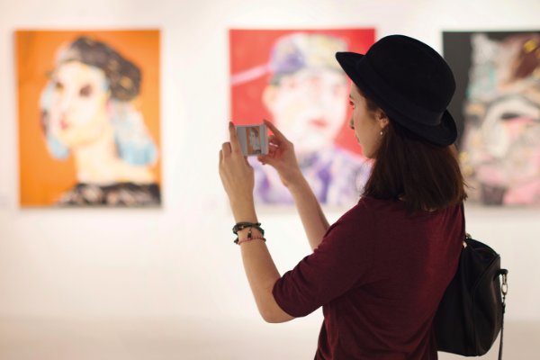 Girl taking picture on her phone in an art gallery