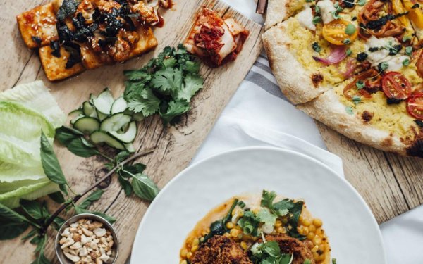 A spread of plant-based dishes at Planta South Beach, showcasing a variety of colorful and artfully presented meals on a beautifully set table