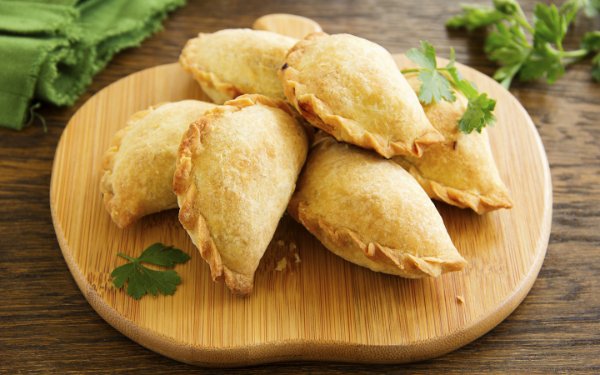 Empanadas presented on a carving board