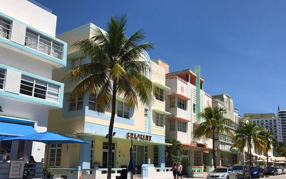 Colorful Art Deco buildings line Ocean Drive in Miami Beach, with palm trees swaying in the breeze