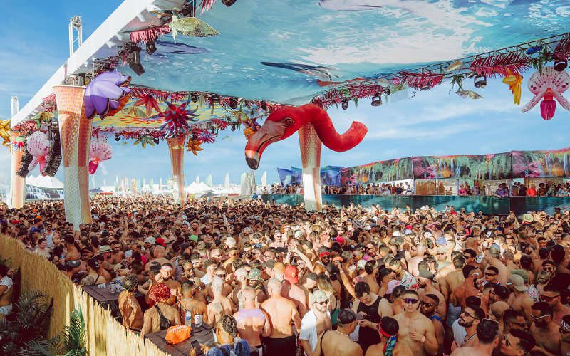 Revelers under a pink flamingo at Winter Party on Miami Beach