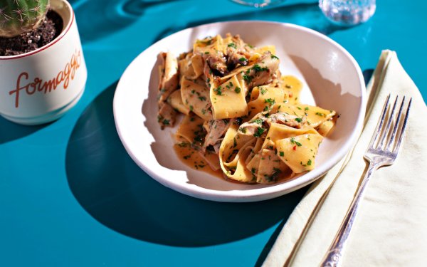 Plate of pappardelle pasta topped with rich, savory sauce, served at Boia De