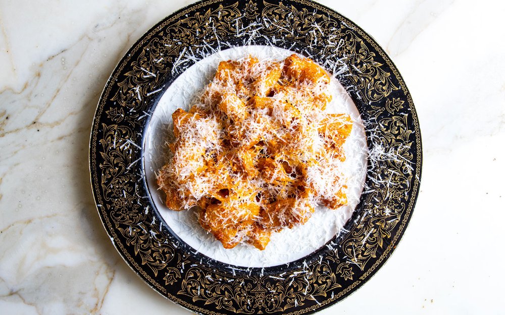 Rigatoni dish, featuring al dente pasta coated in a rich, spicy tomato sauce, garnished with fresh herbs and grated cheese