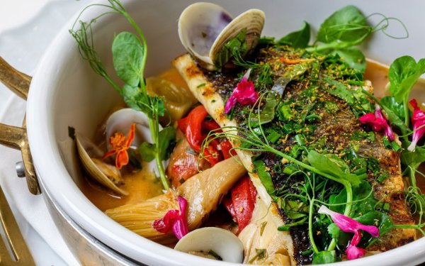 Bowl of exclusive flavors for Miami Spice from Fiola Miami showing fresh herbs and garnishes